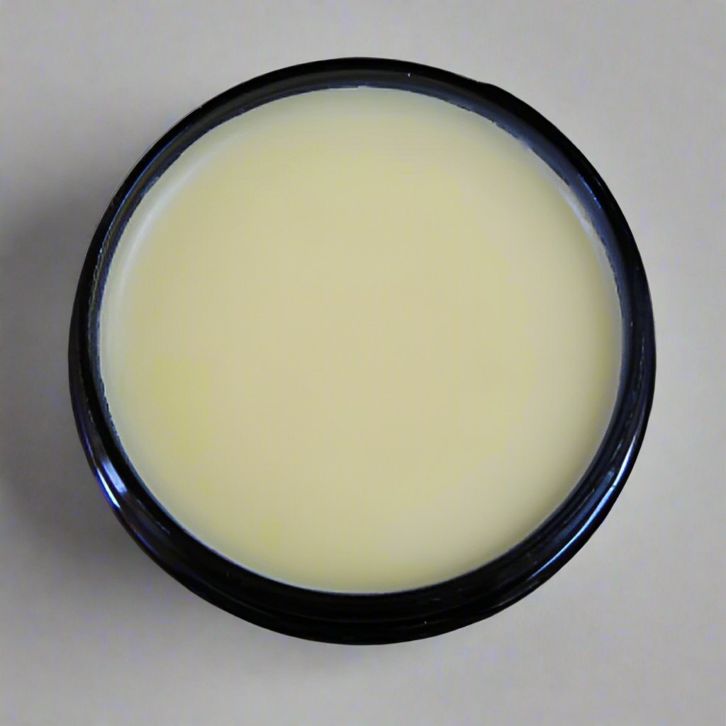 A blue jar of body butter with its lid off, revealing a smooth, creamy texture of yellow body butter inside. The texture appears rich and thick, suggesting a moisturizing formula.