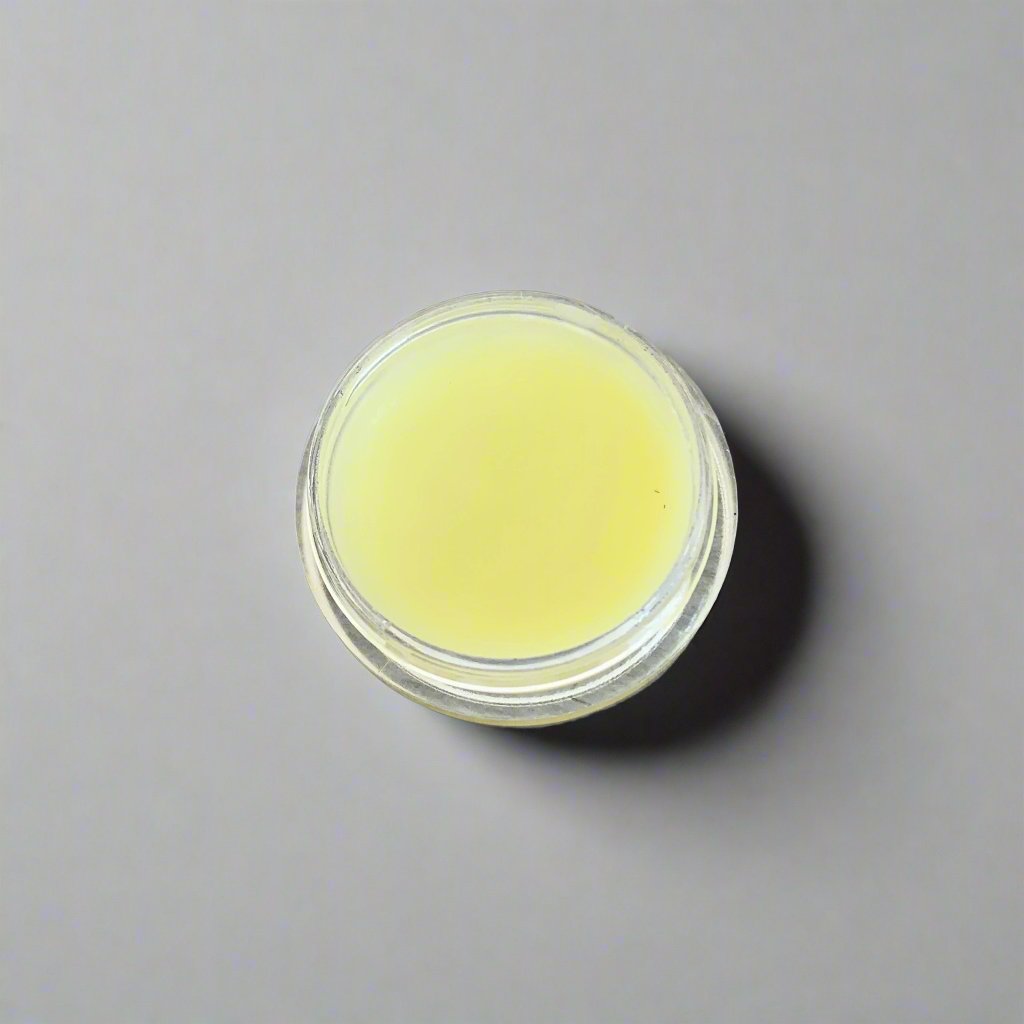 A jar of Coastal Sanctuary Orange Butter Face Cream with a smooth, creamy texture. The jar features a vibrant orange color and is set against a neutral background, highlighting its luxurious appearance.