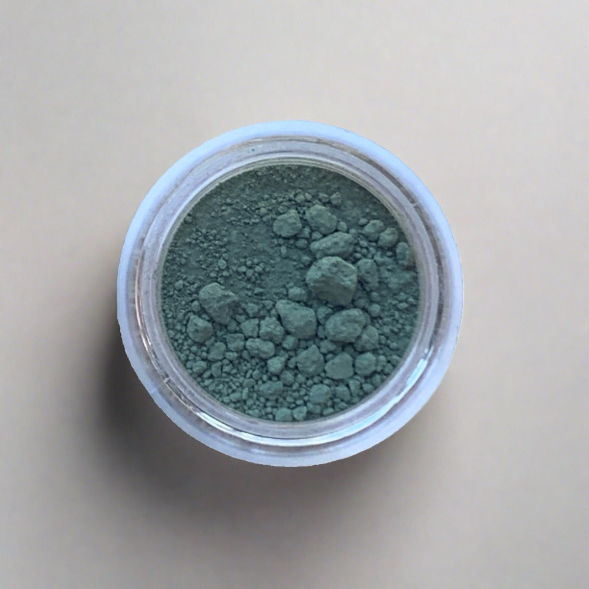 Swatch of cool sage green eyeshadow loose powder, displaying its color