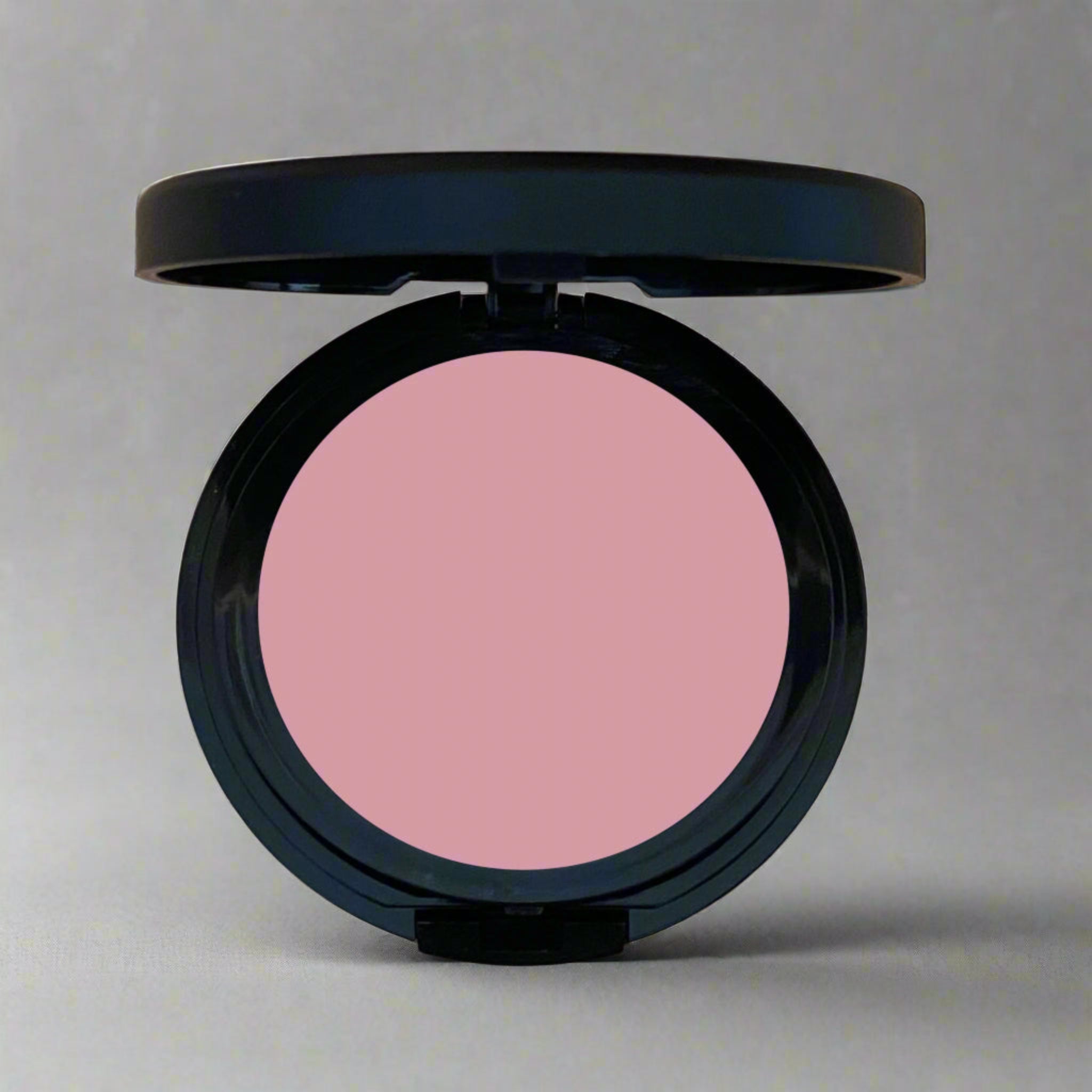 A close-up of Coastal Classic Creations 
Au-Natural Matte Blush, a soft mauve pink shade from the pressed blush line. The blush offers a smooth, matte finish, ideal for a natural, warm glow.