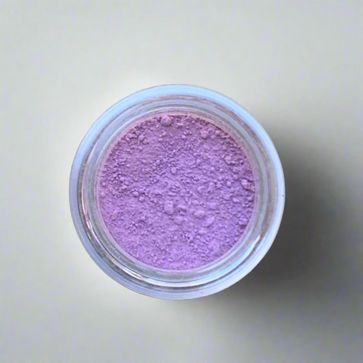 Swatch of soft pink eyeshadow loose powder, displaying its color