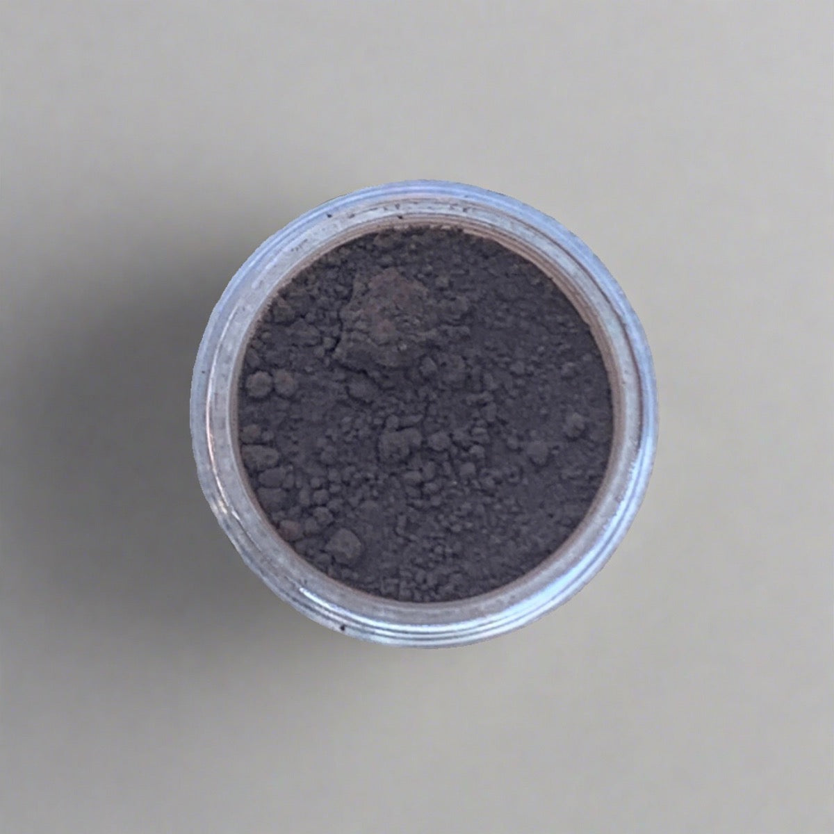 Swatch of greyish brown eyeshadow loose powder, displaying its color