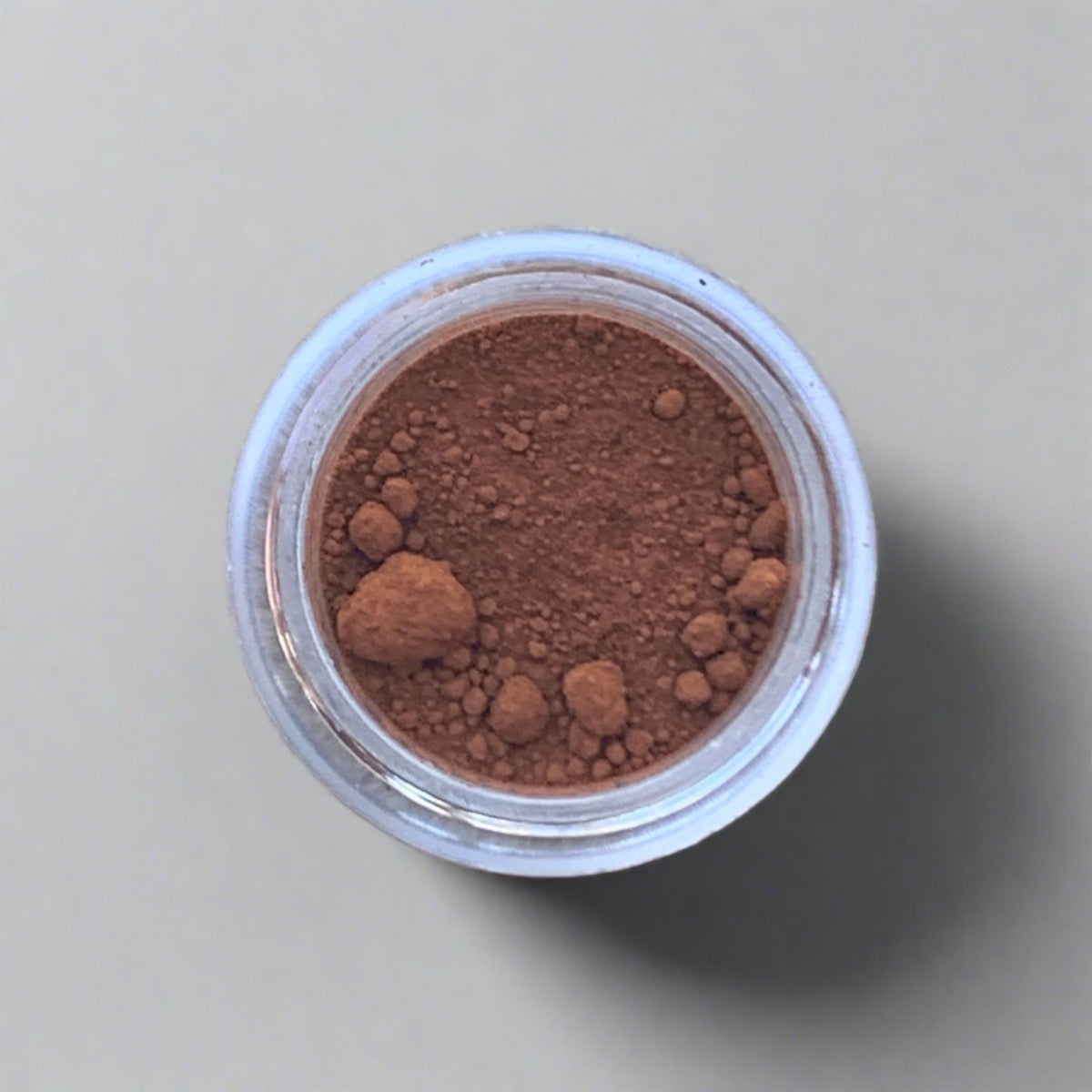 Swatch of burnt orange eyeshadow loose powder, displaying its color