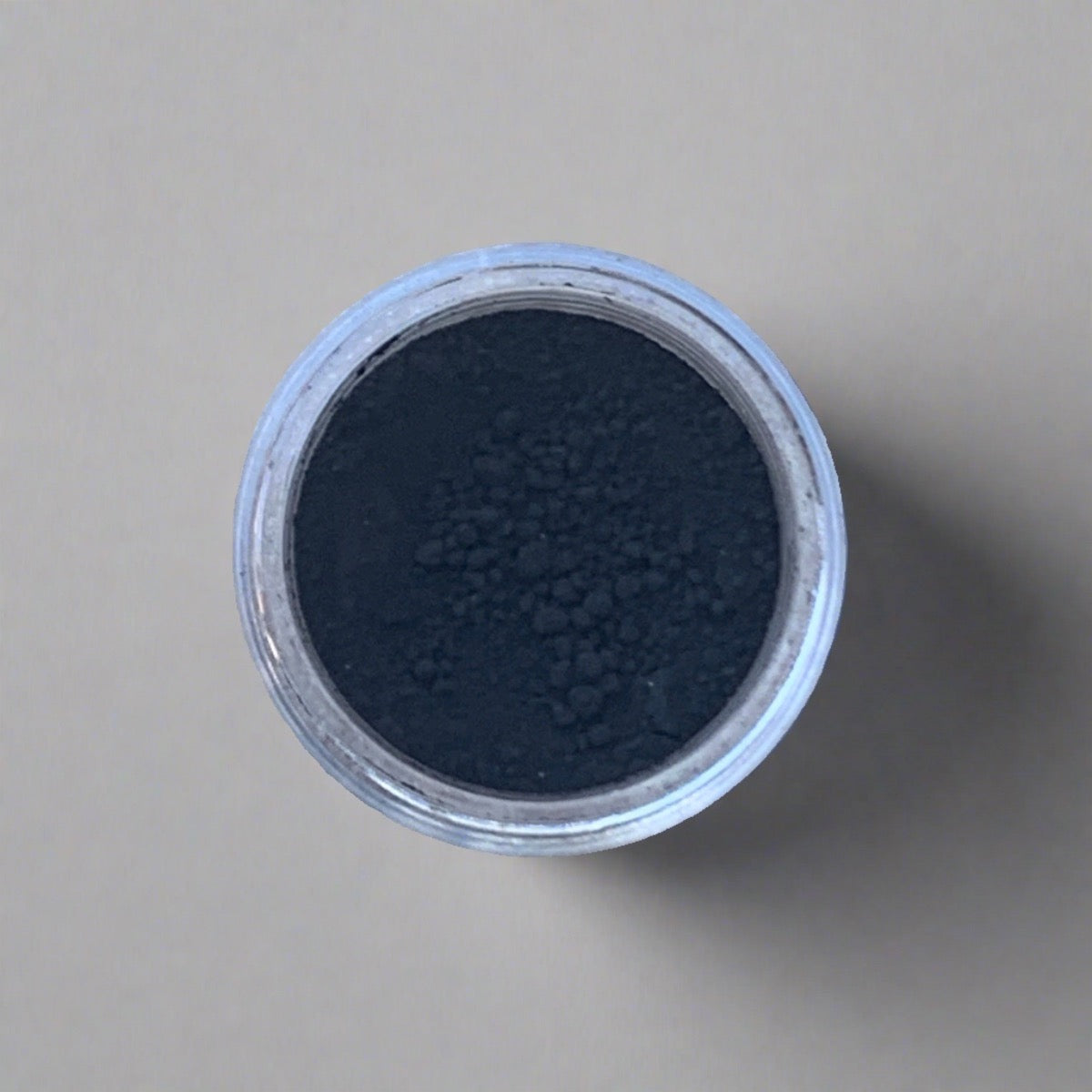 Swatch of jet black eyeshadow loose powder, displaying its color