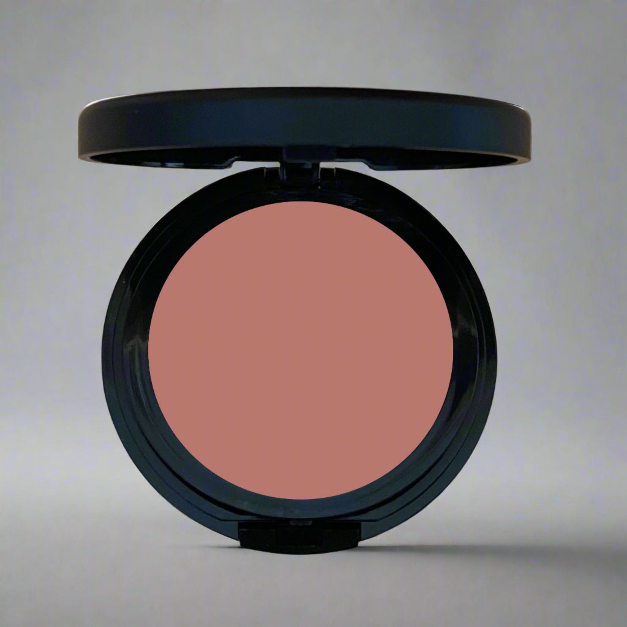 Close-up of a warm terracotta pressed blush in a sleek compact, part of Coastal Classic Creations' mindful beauty collection. Designed to enhance natural beauty with a soft, radiant finish