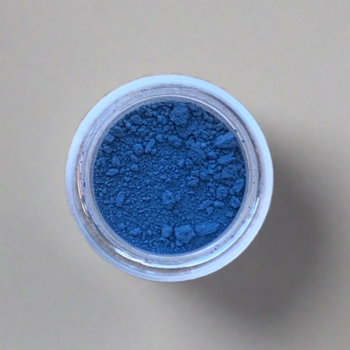 Swatch of bright blue eyeshadow loose powder, displaying its color