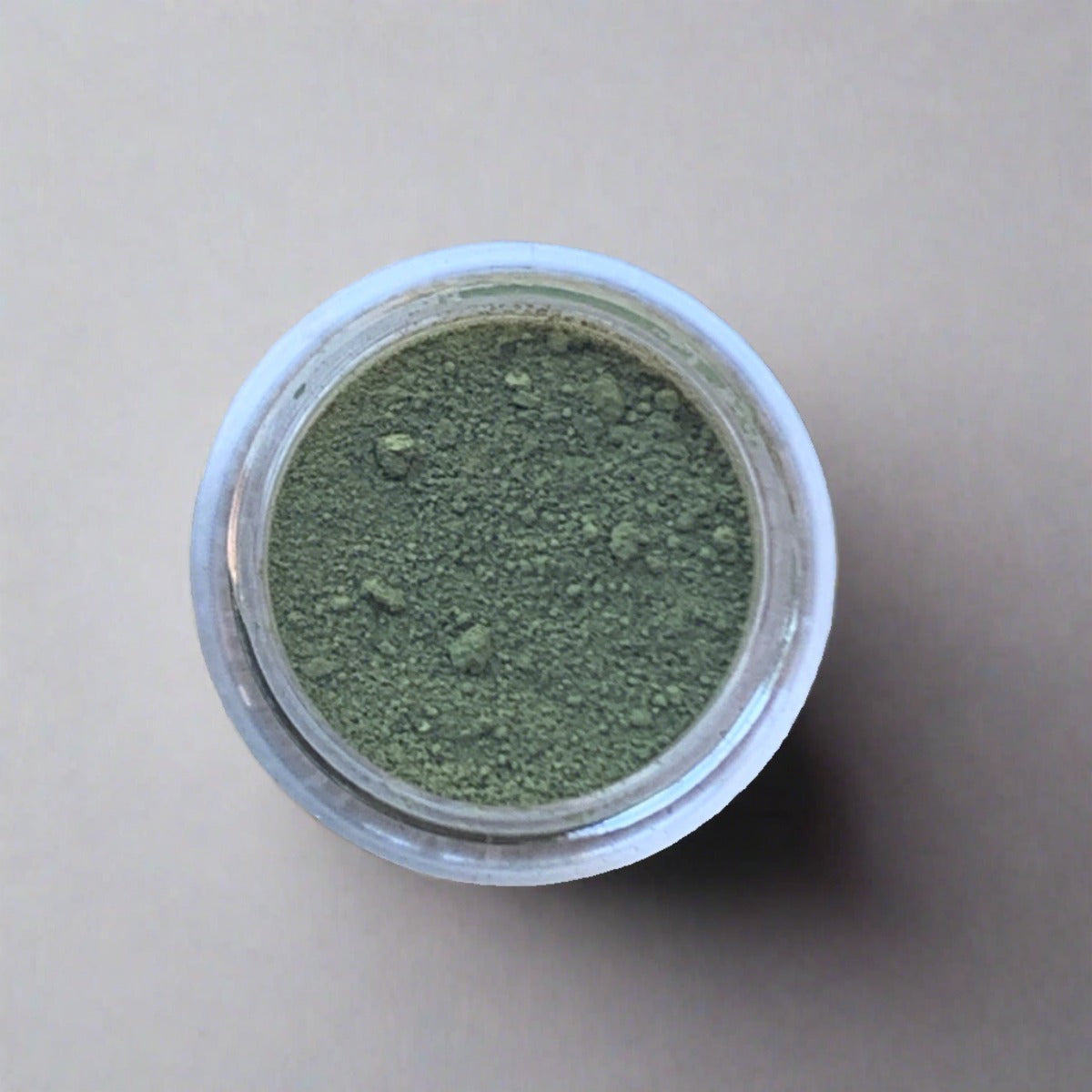 Swatch of olive green eyeshadow loose powder, displaying its color