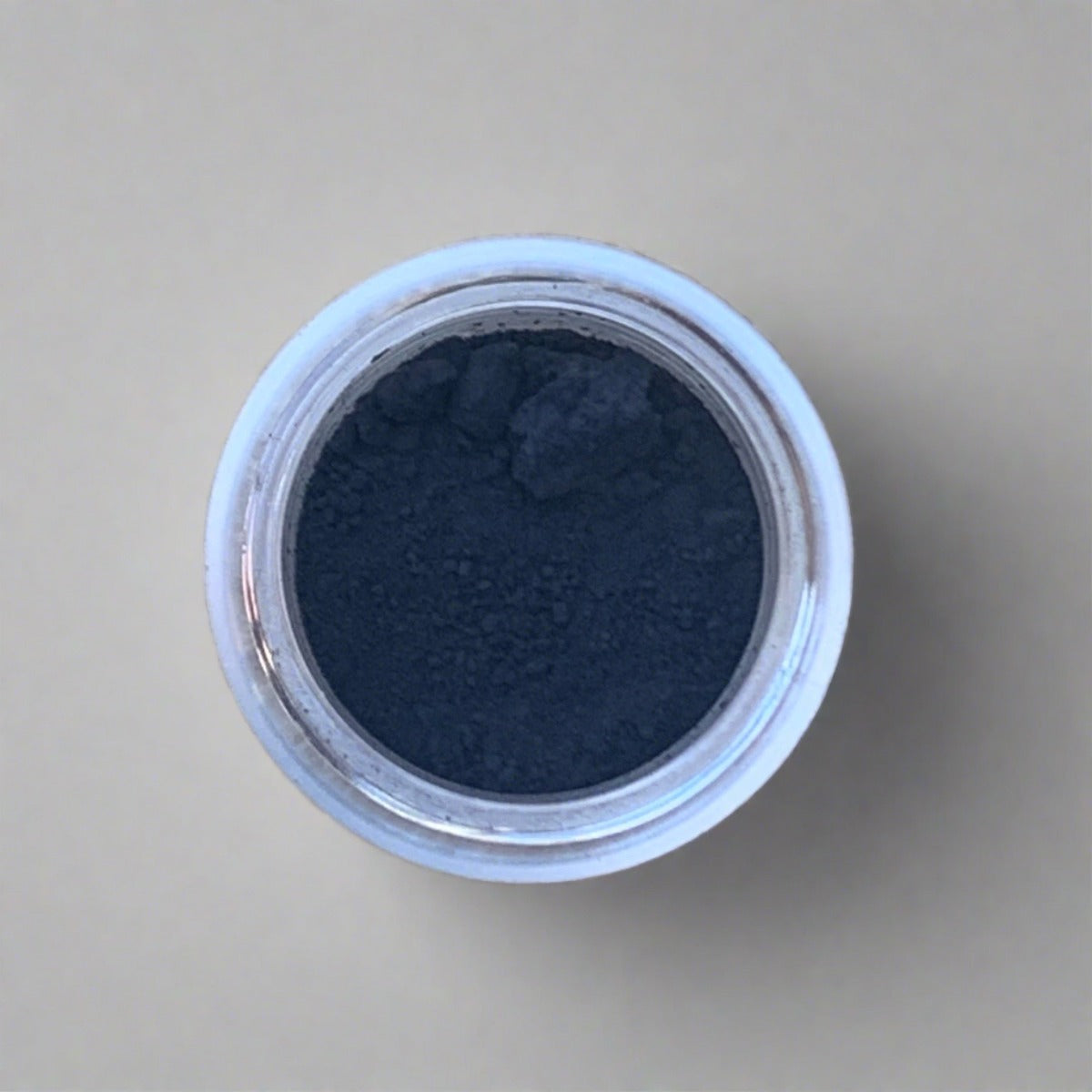 Swatch of dark navy blue eyeshadow loose powder, displaying its color