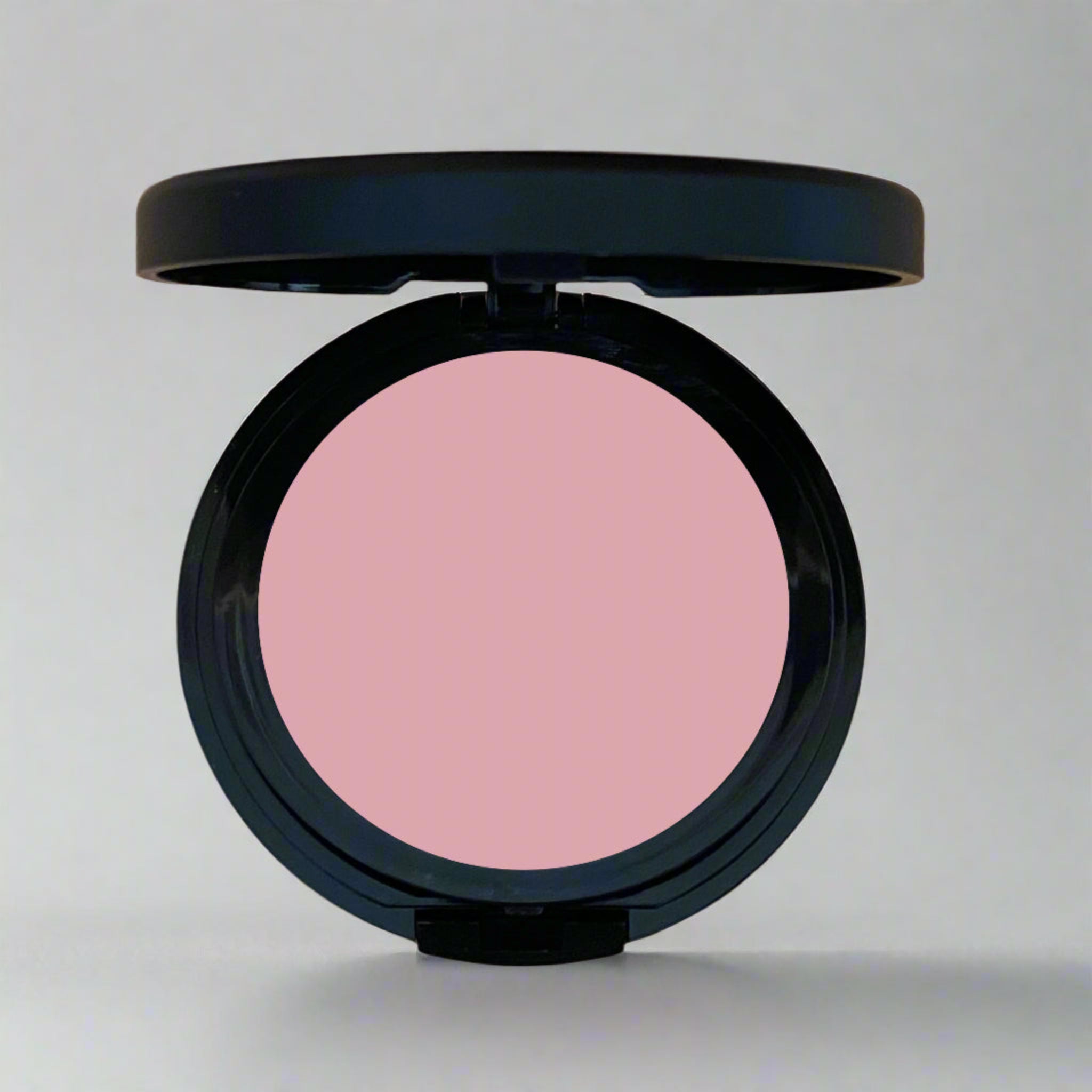 Close-up of a soft dusty rose pressed blush in a sleek compact, part of Coastal Classic Creations' mindful beauty collection. Designed to enhance natural beauty with a soft, radiant finish.