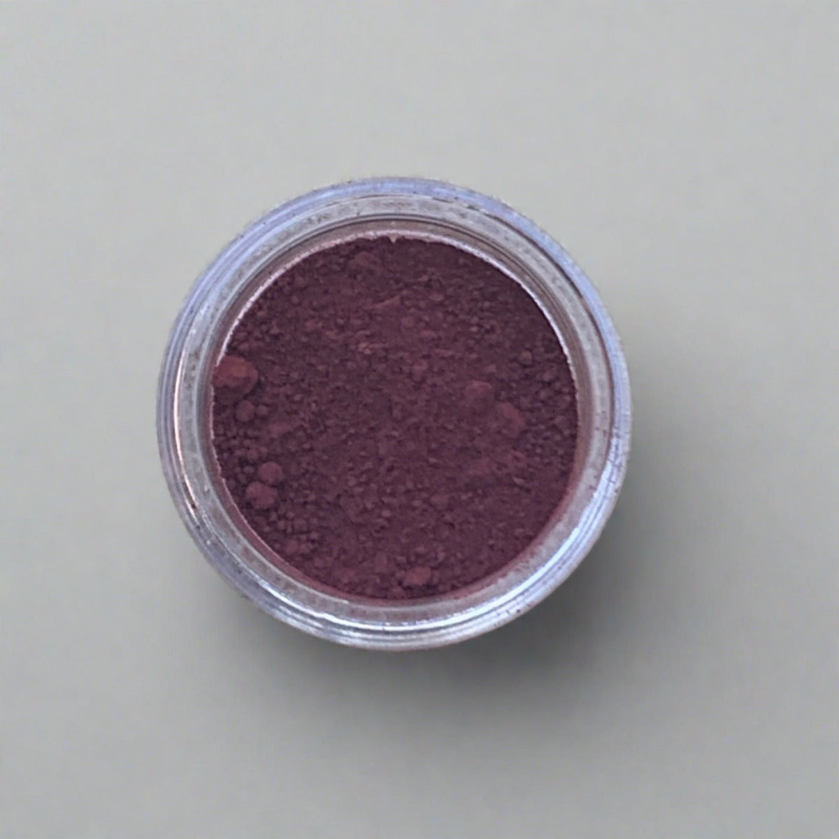 Swatch of rich burgundy eyeshadow loose powder, displaying its color