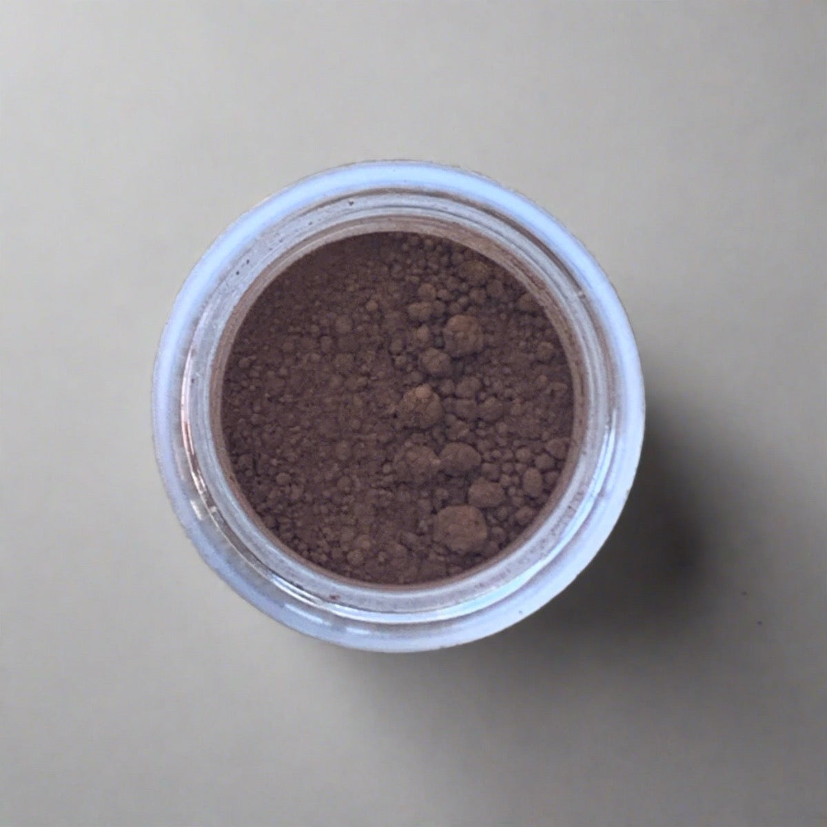 Swatch of earthy cafe brown eyeshadow loose powder, displaying its color