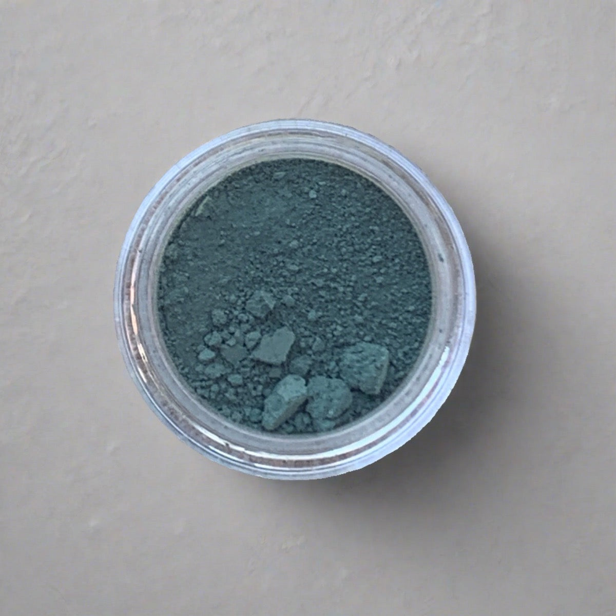 Swatch of green blue eyeshadow loose powder, displaying its color