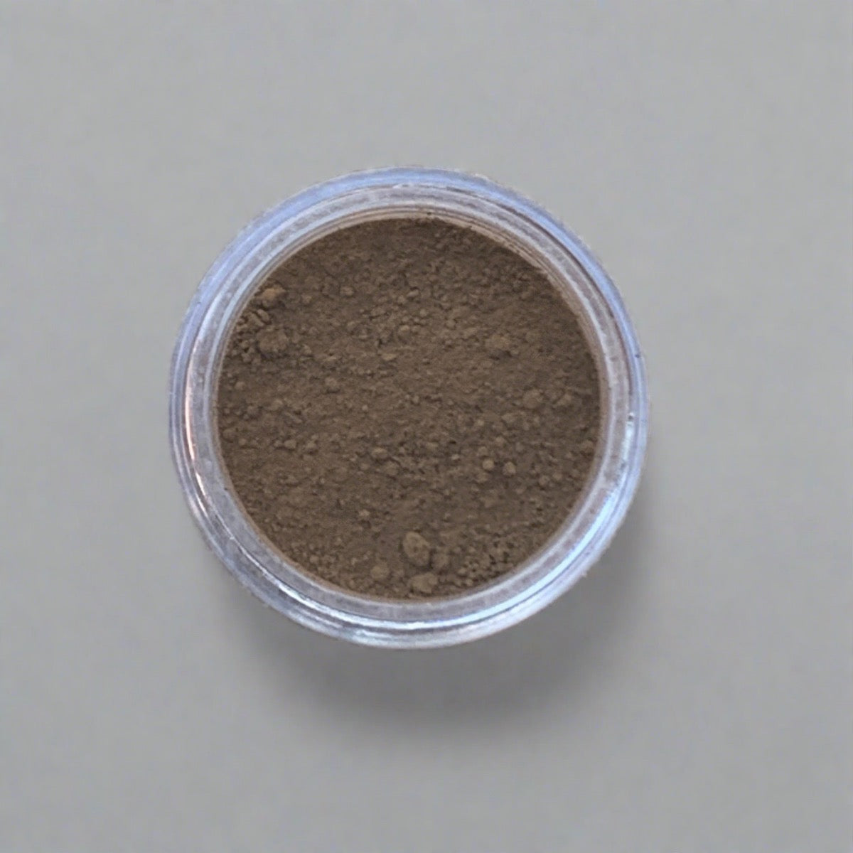 Swatch of earthy brown eyeshadow loose powder, displaying its color